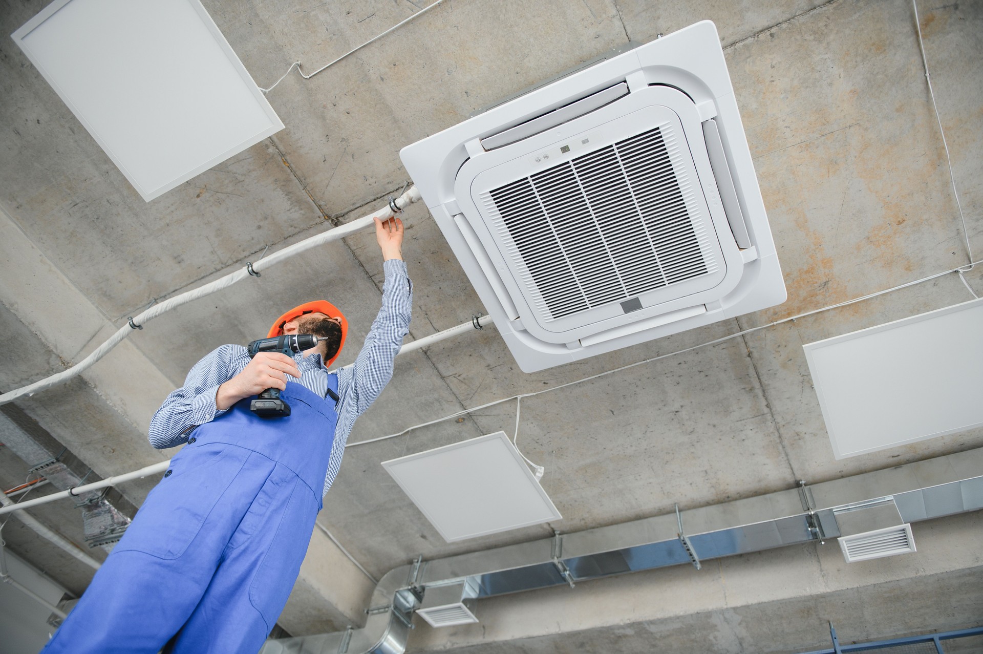 Happy Male Technician Repairing Air Conditioner.